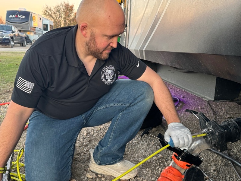 Nick Hastings working underneath an RV performing on-site mobile repair